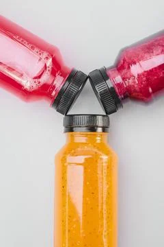 Plastic bottles of cold-pressed unprocessed fruit and vegetable juices, light Stock Photos