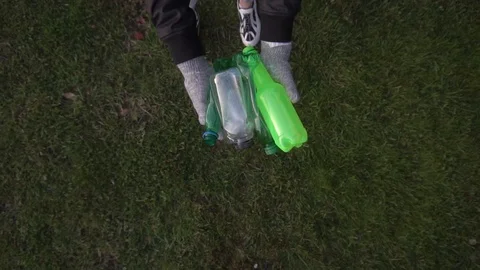Plastic bottles fall to the ground from the hands of a girl in gloves Vidéo 120089975