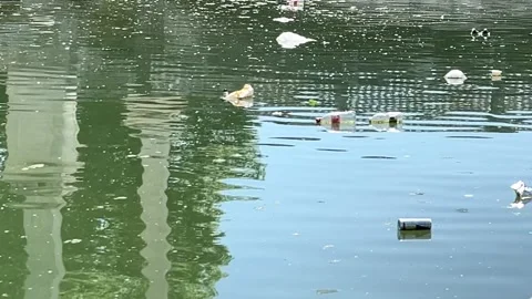 Plastic Bottles, Polyethylene Packaging, and Tin Cans Drifting on Water Surface Video stock 274850475