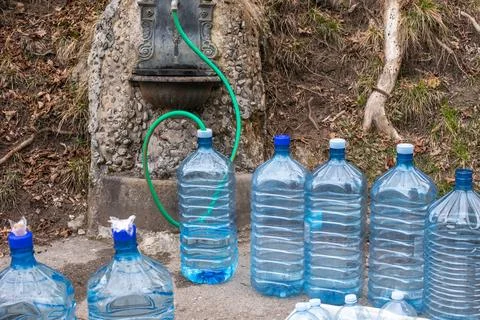 Plastic bottles ready to be filled with clean drinking water. Water emergency. Stock Photos