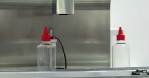 Plastic bottles with red caps moving on automated sauce filling line Stock-Footage 346704627