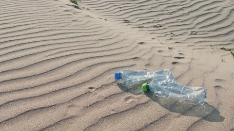 Plastic bottles on the sand at the beach. Long life garbage concept Stock Footage 130809733