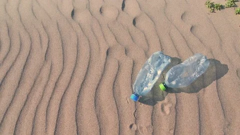 Plastic bottles on the sand at the beach. Long life garbage concept Stock Footage 130809873