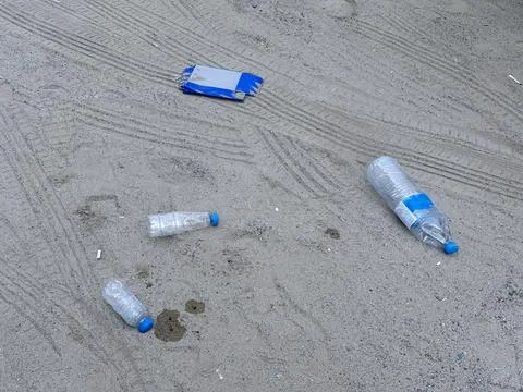 Plastic bottles on sand, environmental pollution Stock Photos