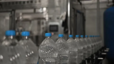 Plastic bottles with water, ride one after another in a row on a conveyor belt Stock Footage 161830158