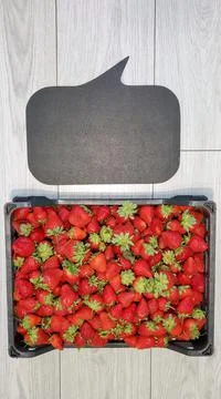Plastic box full of ripe fragrant strawberries. Ripe large strawberries with Stock Photos