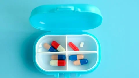 Plastic box pills close-up on blue background top view. Stock Footage 229095051