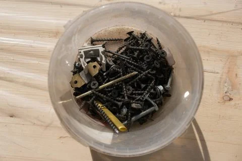 Plastic box with self-tapping screws on a wooden surface top view Foto stock