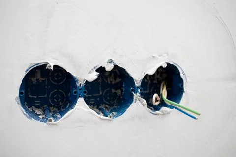 Plastic box sockets and electrical cables on the wall. Stock Photos