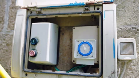 Plastic box with water pump indicator and irrigation timer installed on the wall Stock Footage 259992464