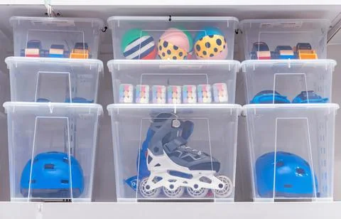 Plastic boxes with children's toys, rollers and a helmet. Stock Photos
