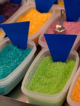 Plastic boxes filled with colored sweets powder Stock Photos