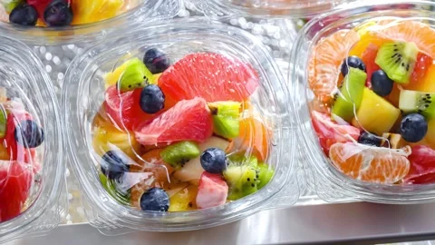 Plastic boxes with pre-packaged fruit salads, put up for sale in a commercial re Stock Footage 244774405