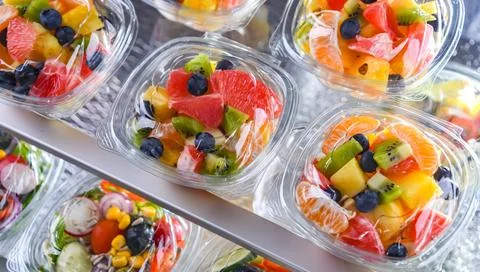 Plastic boxes with pre-packaged fruit salads, put up for sale in a commercial Stock-Fotos