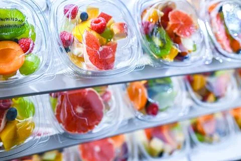 Plastic boxes with pre-packaged fruit salads, put up for sale in a commercial Stock Photos