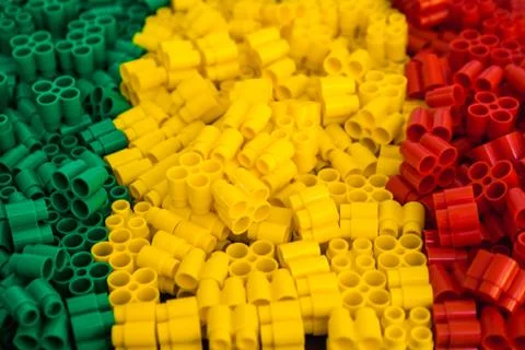 Plastic bricks of red, yellow and green. Details of toys. Close up. Stock Photos