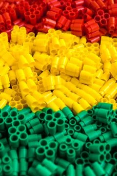 Plastic bricks of red, yellow and green. Details of toys. Close up. Stock Photos