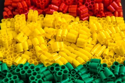 Plastic bricks of red, yellow and green. Details of toys. Close up. Stock Photos