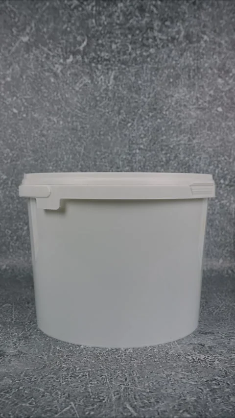 Plastic bucket on grey background. Space for text. Vertical video. Stop motion Stock Footage 282648322