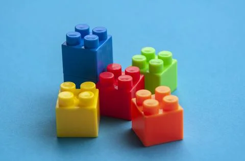 Plastic building blocks on blue background. Copy space concept Stock Photos