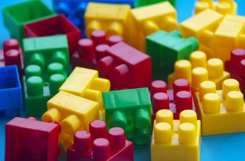 Plastic building blocks on blue background. Copy space Stock Photos