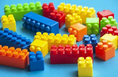 Plastic building blocks on blue background. Educational concept Stock Photos