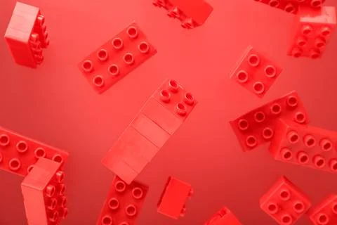 Plastic building blocks levitating on red background Stock Photos