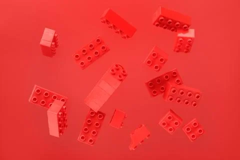Plastic building blocks levitating on red background Stock Photos