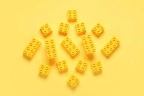 Plastic building blocks on yellow background Stock Photos