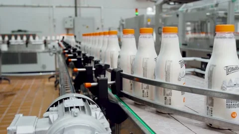 Plastic cans of milk move on a conveyor belt. Cloce-up Stock Footage 136078114