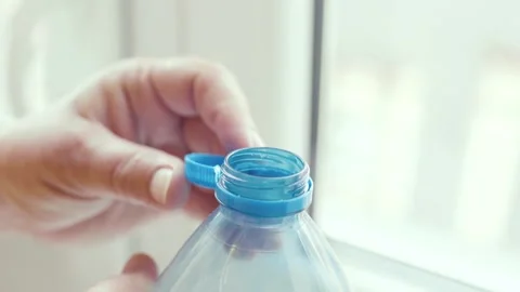 Plastic cap connected to a plastic bottle. Bottle design with the cap attached t Stock Footage 311535354
