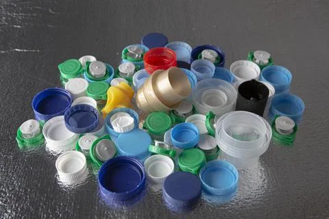 Plastic caps of different sizes and colors on a silver background Foto stock