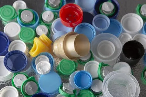 Plastic caps of different sizes and colors on a silver background Foto stock