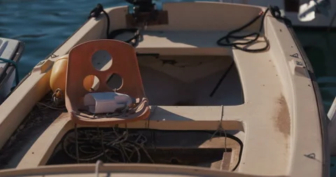 Plastic chair inside small boat in harbor Stock-Footage 334339189