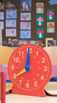 Plastic children's analog clock in the classroom for interactive learning hours Stock Photos