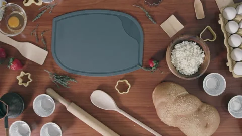 Plastic chopping board surrounded by ingredients on table Stock Footage 229844989