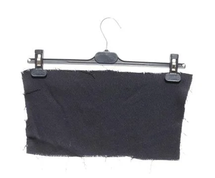 Plastic clothes hanger with hanging on it a piece of black cloth  isolated on Stock-Fotos