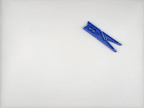 Plastic clothespin multi-colored with a blue metal spring on a white background Stock Photos