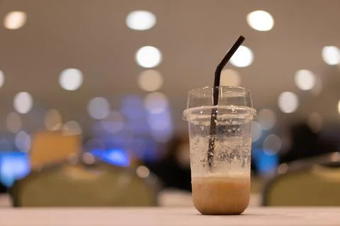 A plastic coffee cup that was almost empty was placed on the table. bokeh l.. Stock Photos