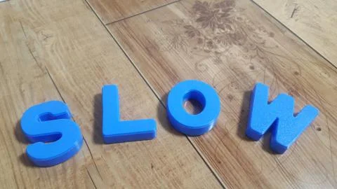 Plastic colored alphabets making words are placed on a wooden floor Foto stock