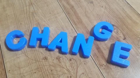 Plastic colored alphabets making words are placed on a wooden floor Stock Photos