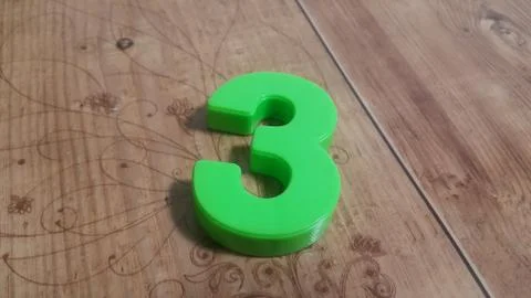 Plastic colored alphabets making words are placed on a wooden floor Stock Photos