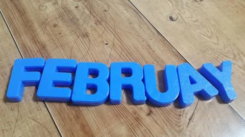 Plastic colored alphabets making words February are placed on a wooden floor Stock Photos