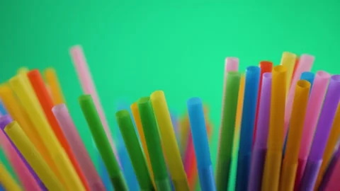 Plastic colored cocktail beverage tubes rotate on a green background. Stock Footage 130637879