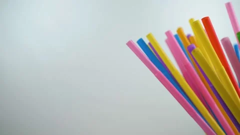 Plastic colored cocktail beverage tubes rotate on a white background Stock Footage 132490324