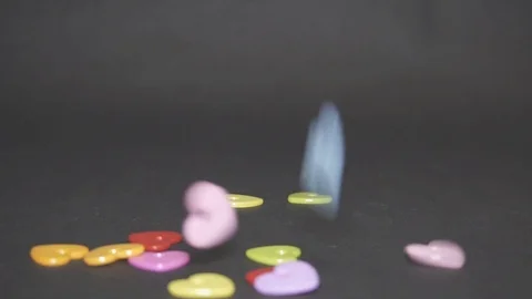 Plastic colored hearts strew on a black background Stock Footage 99368889