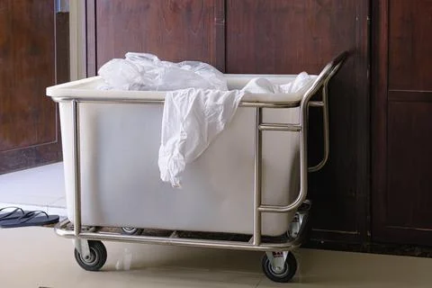 Plastic container for dirty bed linen on a metal trolley on wheels Stock Photos