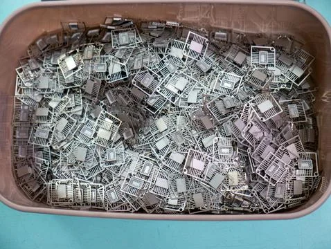 Plastic Container Filled with Metal Microchip Lead Frames Stock Photos
