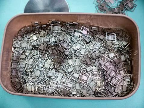 Plastic Container Filled with Microchip Lead Frames Stock-Fotos