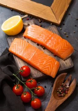 Plastic container with fresh salmon slice with oil tomatoes and lemon Stock Photos